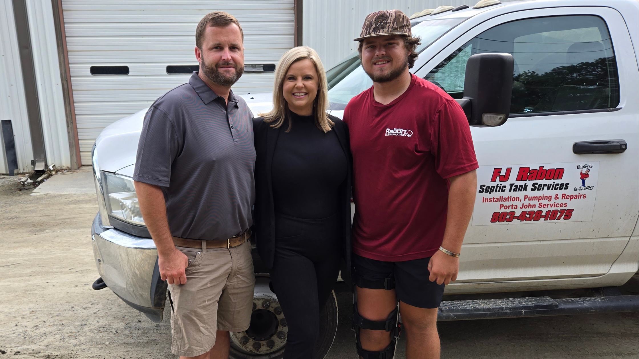 Family photo of Ben, Ashleigh, and Will Rabon in front of FJ Rabon truck and business