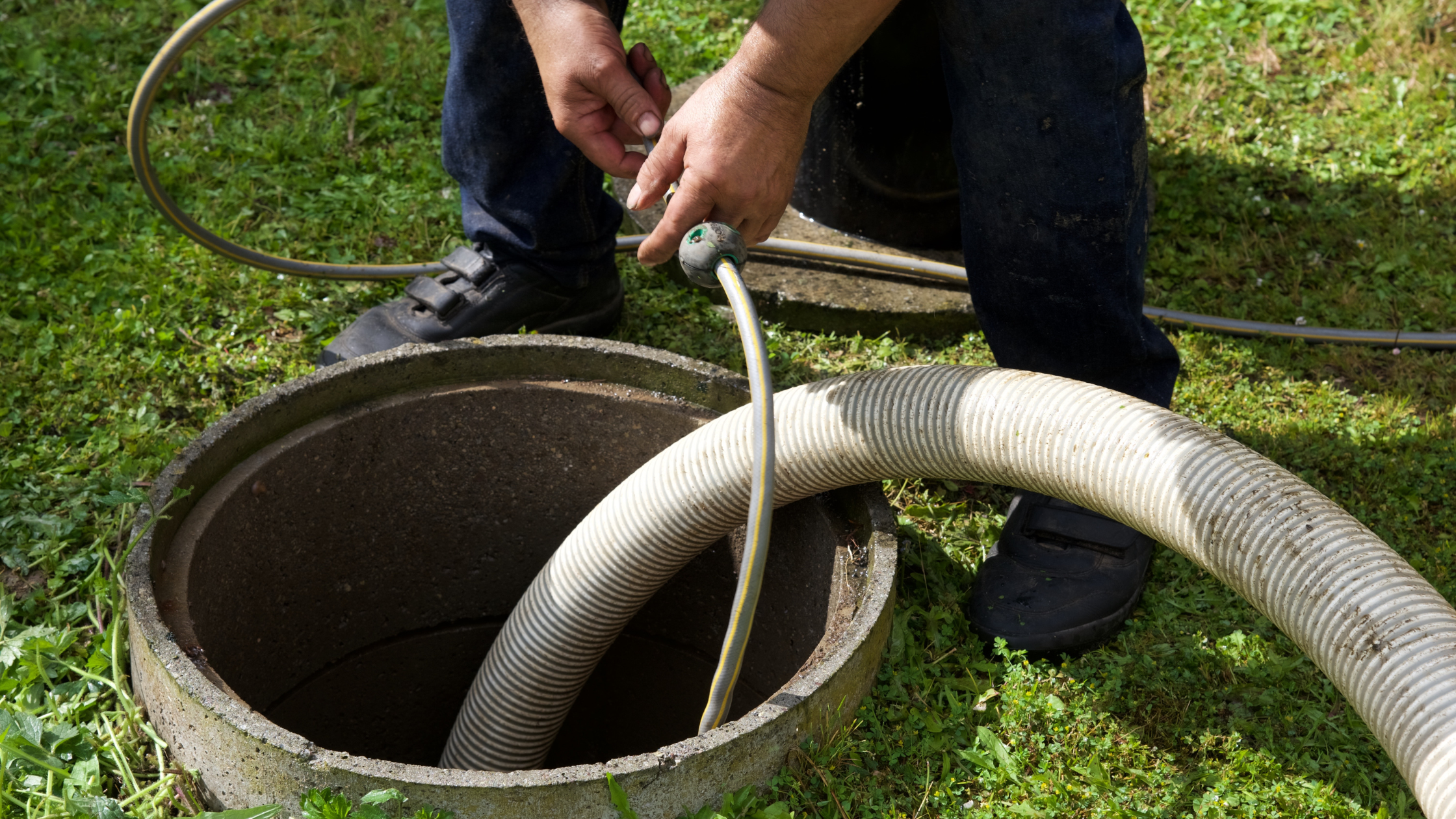 man pumping septic tank with hose